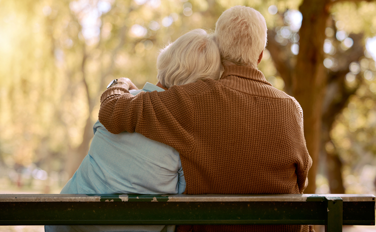 Older couple on a bench embracing